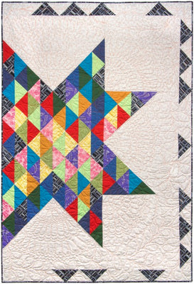 A throw quilt with a single large multicoloured star across a pale background, finished at 49.5 by 71 inches