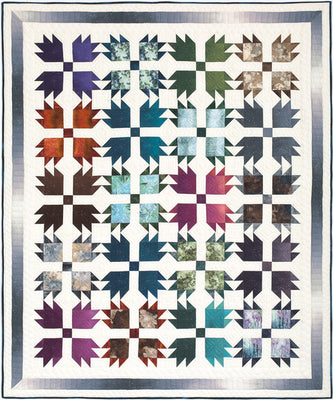 Forest Tracks quilt with paw print blocks in deep woodland tones on a cream background