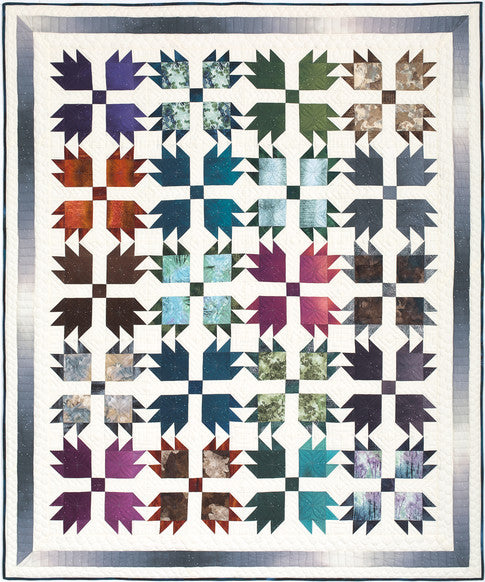 Forest Tracks quilt with paw print blocks in deep woodland tones on a cream background