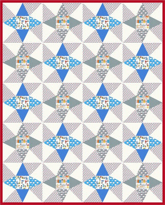 Montmarte quilt with blue and grey star points around printed centre squares on a cream background