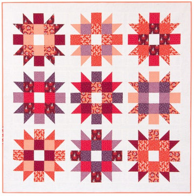 Genny and Ruth quilt with nine large blooming star blocks in warm tones on a soft background
