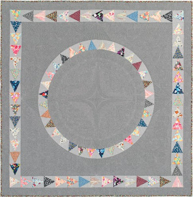 West End quilt with two rings of small colourful triangles on a soft grey background