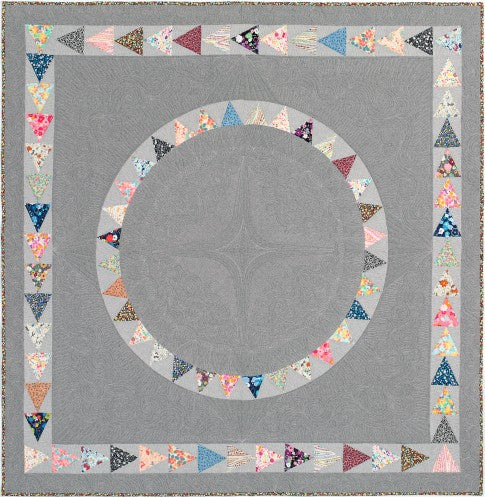 West End quilt with two rings of small colourful triangles on a soft grey background