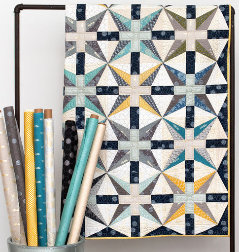 Starry Night quilt with large eight pointed stars in navy, cream and gold on a softly mixed background