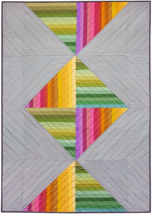 Spectrum Candy quilt, rainbow strip pieced triangles meeting in the centre on a soft grey background