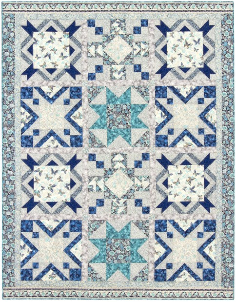 Stars Aflutter quilt, a sampler of blue and teal star blocks with soft floral centres on a grey background