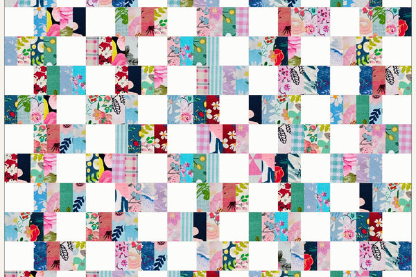 Alder quilt in Blossom Breeze prints, rows of four pink, aqua and navy strips alternating with white squares that stagger from row to row