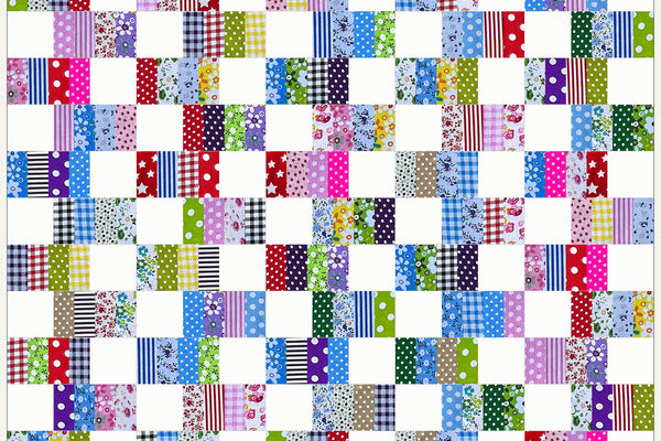 Alder quilt in Patchwork Carnival prints, rows of checks, stripes and polka dots alternating with white squares that stagger from row to row