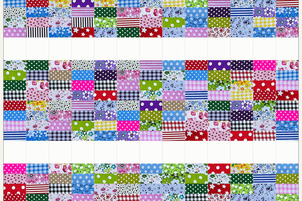 Aspen quilt in Patchwork Carnival prints, wide bands of checks, stripes and dots separated by bands of white squares across the quilt