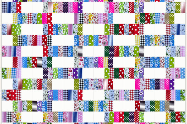 Blackthorn quilt in Patchwork Carnival prints, white blocks and bands of checks, stripes and dots staggered like brickwork across nineteen rows