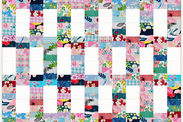 Dogwood quilt in Blossom Breeze prints, white squares meeting in pairs to form windows inside a lattice of pink, aqua and navy strips