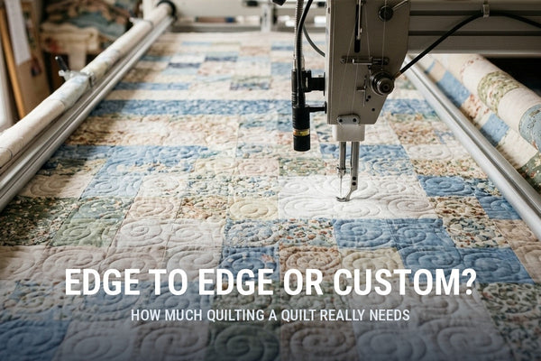 Longarm machine stitching an edge to edge swirl design across a blue and cream patchwork quilt on the frame