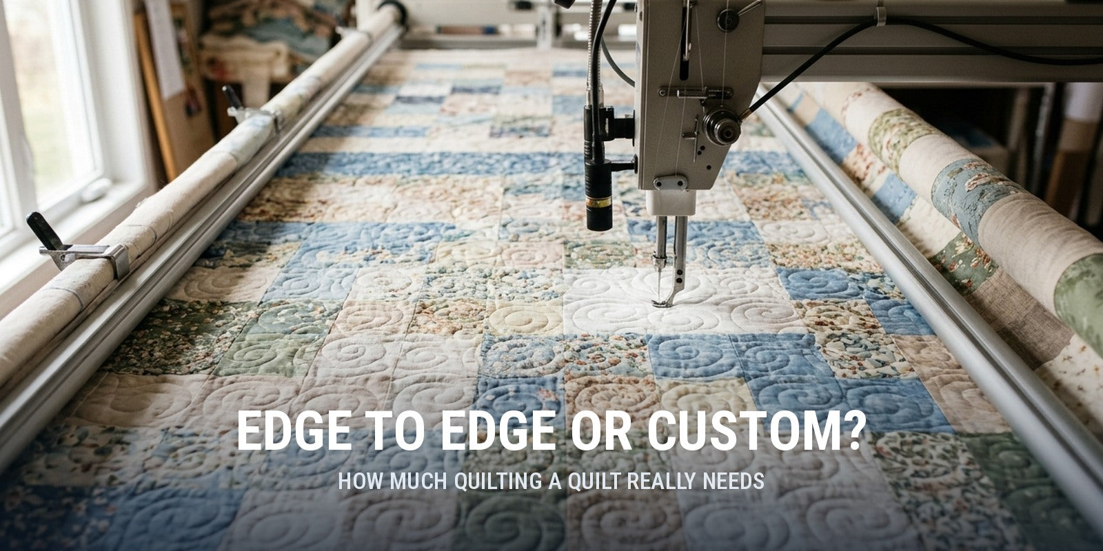 Longarm machine stitching an edge to edge swirl design across a blue and cream patchwork quilt on the frame