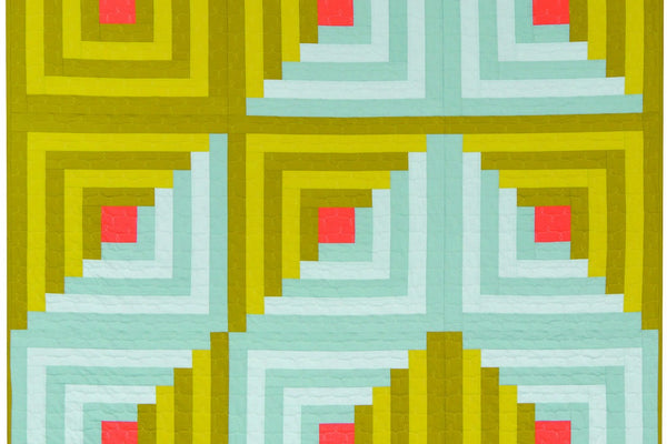 Log cabin quilt of nine 24 inch blocks in two greens and two pale aquas, each block centered on a coral square, with the top left block worked entirely in green