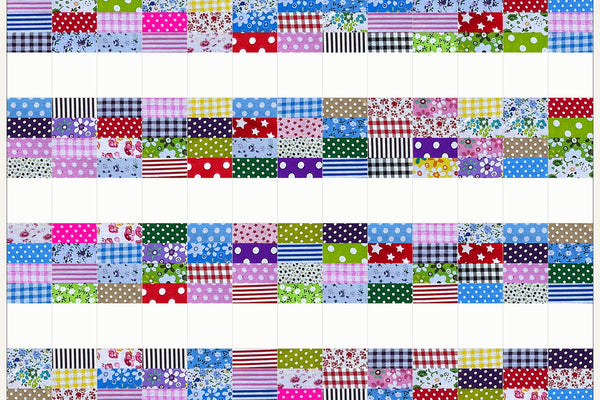 Hazel quilt in Patchwork Carnival prints, five rows of bright strips and white squares all facing the same way with a last row of strips and no squares