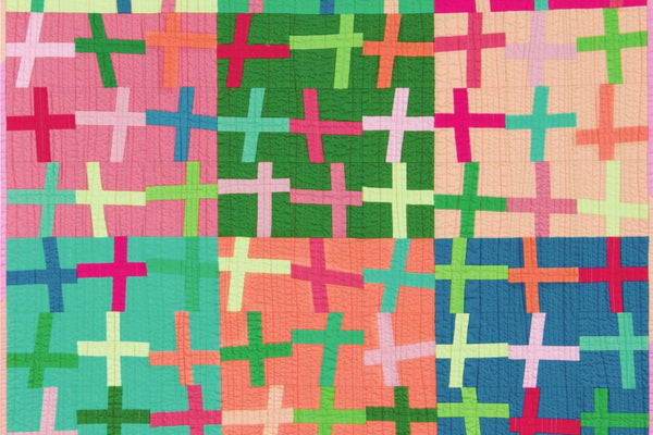 The finished Kona Crossing quilt, 45 by 60 inches, with 108 wonky cross blocks on twelve Kona solid backgrounds