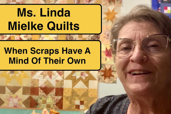 a scrappy star quilt in yellows and browns with a border of small wonky star blocks around the outside