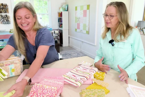 a novelty focal print with coordinating pink, green and yellow fabrics laid out on a white background