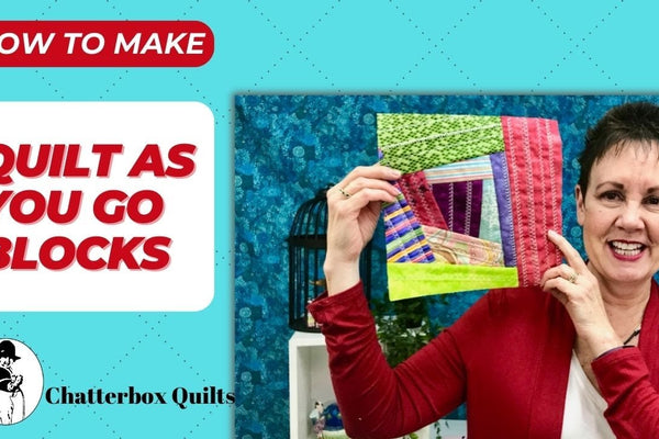 Improvisational quilt as you go block built from fabric scraps on a square of batting, with rows of utility stitches quilted across each piece