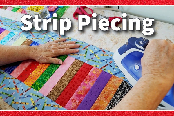 A quilt made from two inch strips in bright colors, framed with sashing and a pieced piano key border