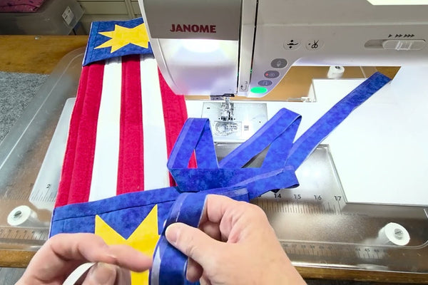 Yvonne of The Fabric Hut machine sewing quilt binding with fusible web tape along the folded edge