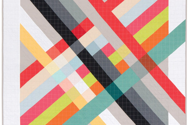 Pique Nique modern quilt in solids with black, gray, red, pink, lime, orange and teal stripes crossing diagonally over a central patchwork square and continuing through a white border