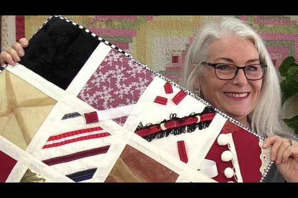 Squares of fidget quilt fabric embellished with zippers, buckles, ribbon loops and fur, joined by white fabric tape