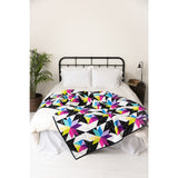 Stars at Sea quilt styled on a bed, modern black and bright star quilt