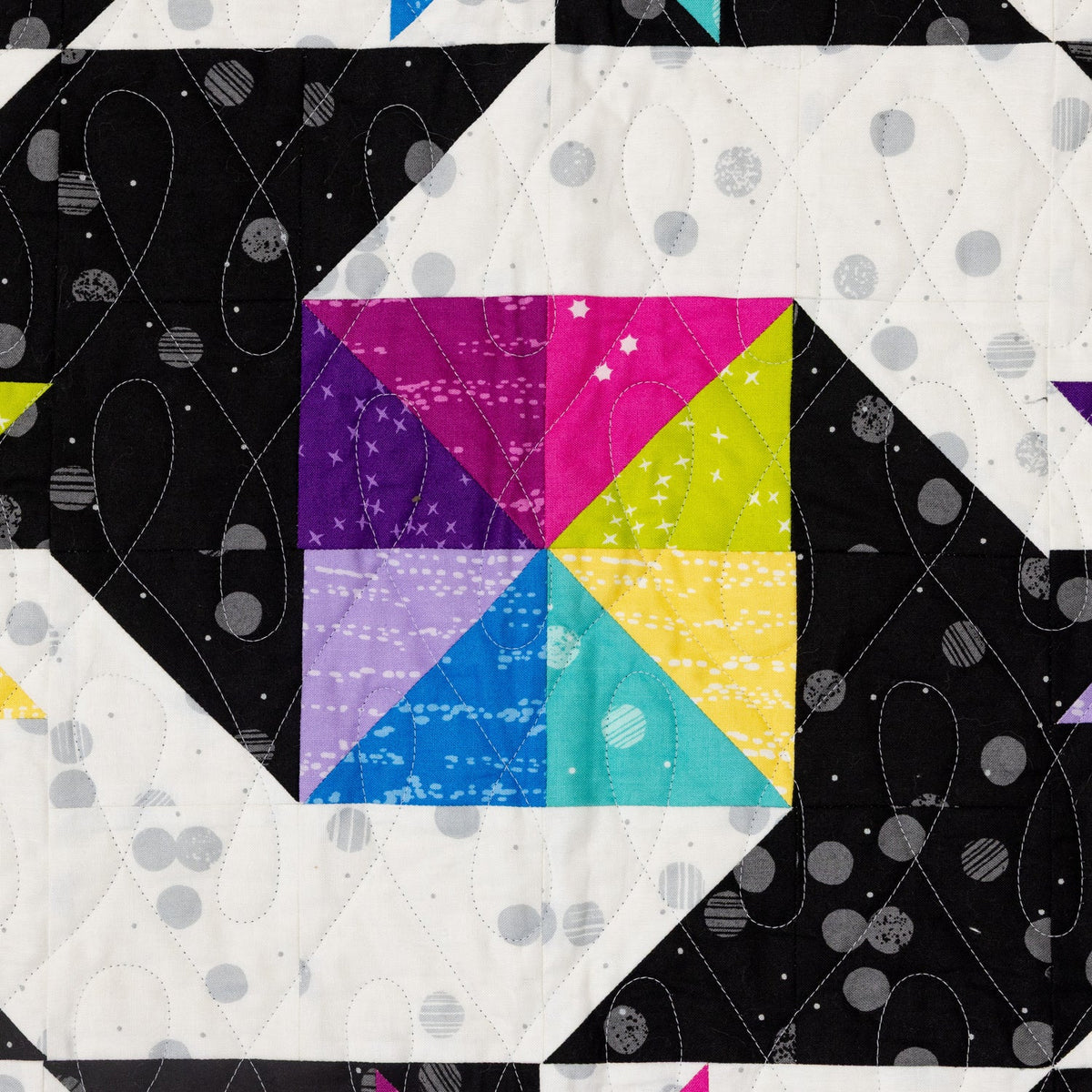 Close up of the star block in Stars at Sea, half square triangles in bright FIGO fabrics