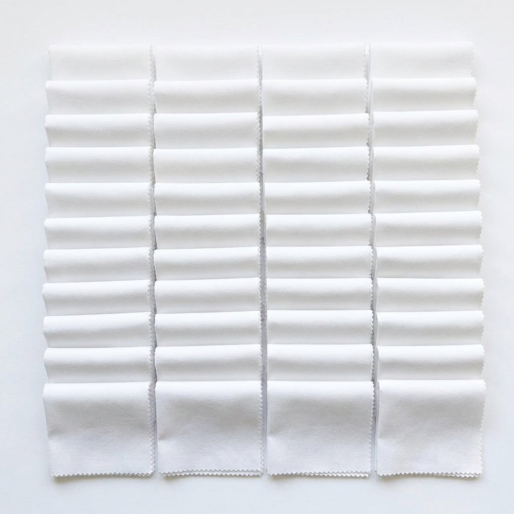 White Supreme 5 inch precut squares laid out in a grid, 42 charm squares
