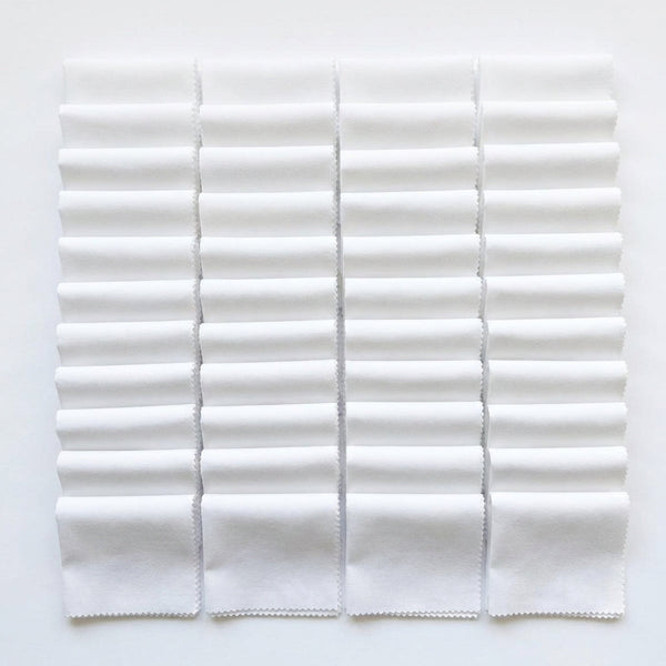 White Supreme 5 inch precut squares laid out in a grid, 42 charm squares