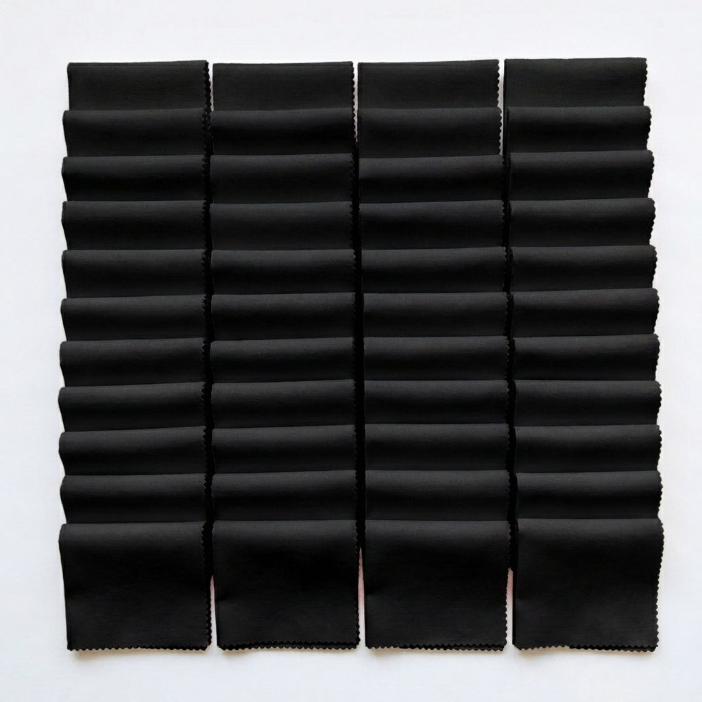 Black Supreme 5 inch precut squares laid out in a grid, 42 charm squares