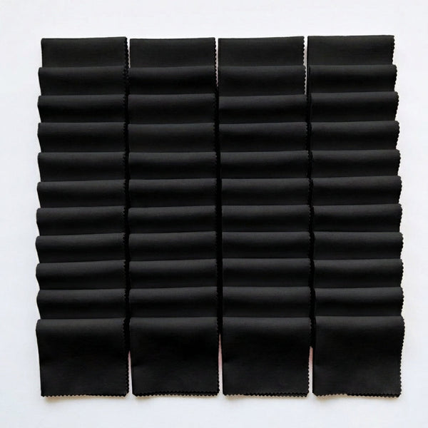 Black Supreme 5 inch precut squares laid out in a grid, 42 charm squares